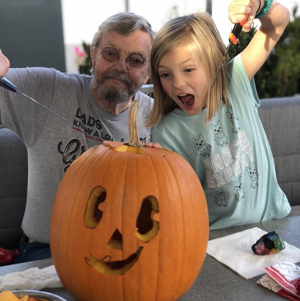 grandpa and child carving pumpkin