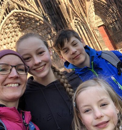 Mom and 3 kids with cathedral in background