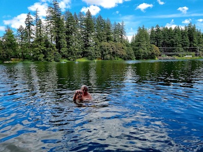 Boy splashing in the lake with grandpa